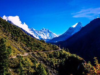 Scenic view of snowcapped mountains against blue sky