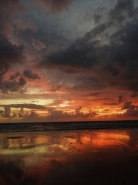 Scenic view of lake against dramatic sky during sunset