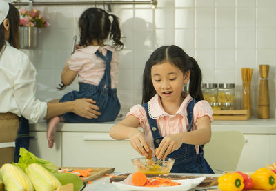 Happy friends and vegetables in kitchen at home