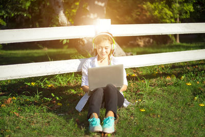 Full length of young woman using mobile phone