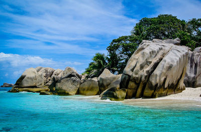 Scenic view of rocks in sea against sky