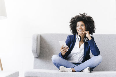 Young businesswoman using smartphone with headset