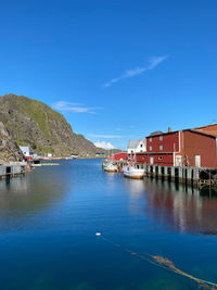 Scenic view of sea by buildings against blue sky