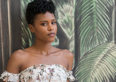 Portrait of young woman against patterned wall