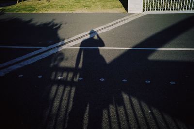Shadow of people riding motorcycle on road