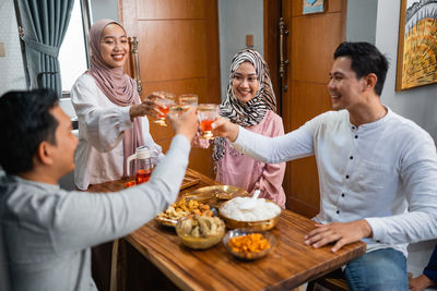 Friends toasting drinks on table