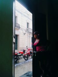 Rear view of woman standing by building