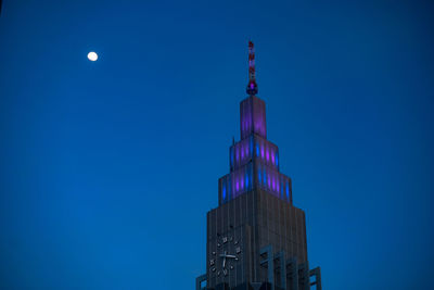 Low angle view of illuminated building against blue sky