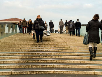People on staircase against sky