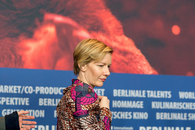 Close-up of young woman with arms outstretched at night