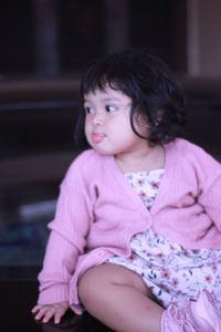 Cute girl looking away while sitting at home