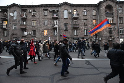 Group of people walking on road in city