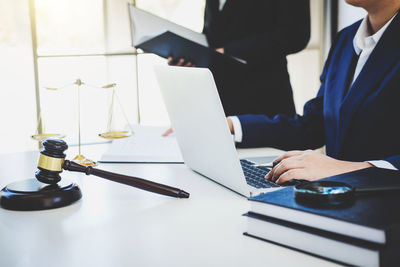 Midsection of lawyer and assistant working in courtroom