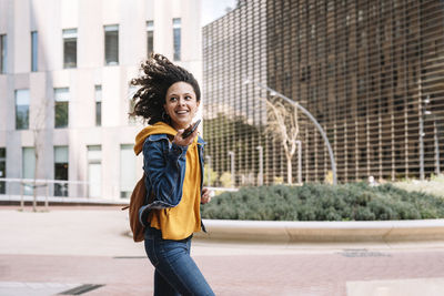 Portrait of smiling mid adult woman standing in city