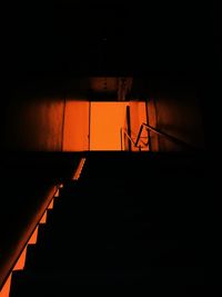 Silhouette staircase in illuminated building against sky during sunset