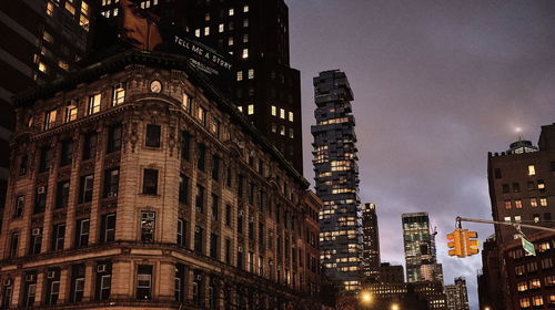 Low angle view of illuminated buildings against sky at dusk