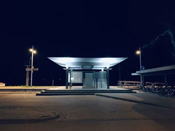 Illuminated street lights against clear sky at night