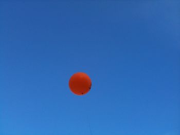 Close-up of red moon in blue sky