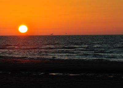 Scenic view of sea against orange sky