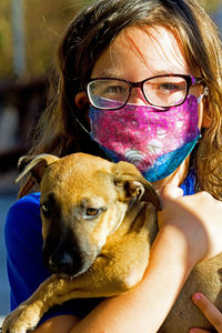 Portrait of girl in mask with dog