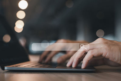 Cropped hand using laptop on table