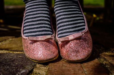 Low section of woman wearing pink shoe