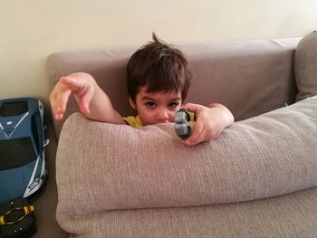 Portrait of boy sitting on sofa at home