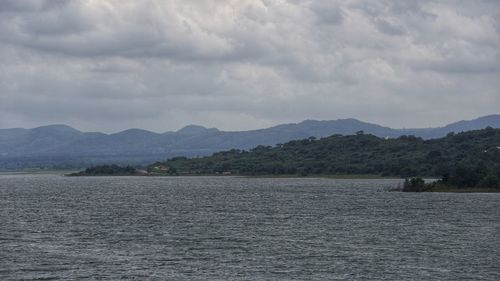 Scenic view of sea and mountains against sky