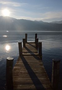 Wooden pier over lake against sky