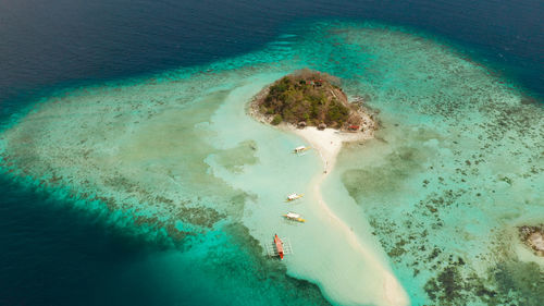 Aerial seascape tropical island and sand beach, turquoise water and coral reef. malacory island