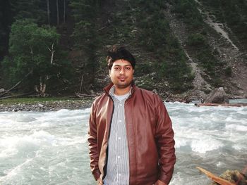 Portrait of young man standing in forest