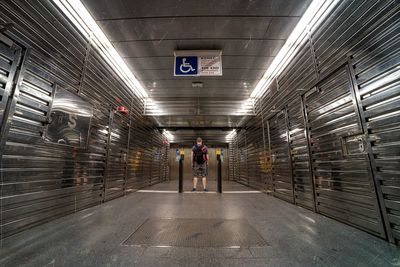 Rear view of man standing in walkway