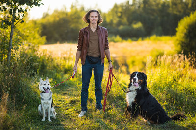 Full length of man with dogs on field