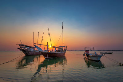 Sailboat in sea against sky during sunset