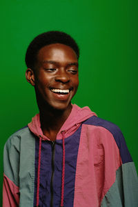Portrait of young man standing against blue background