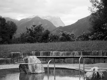 Scenic view of river by mountains against sky