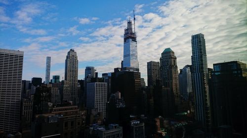 Skyscrapers in city against cloudy sky
