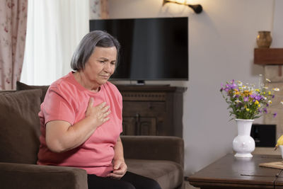 Woman sitting on sofa at home