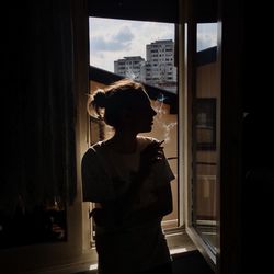 Woman smoking cigarette at window