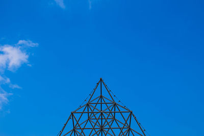 Low angle view of metallic structure against blue sky