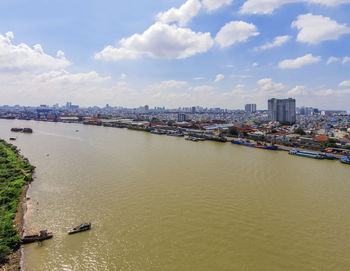 Scenic view of river by city against sky