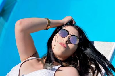 Portrait of young woman wearing sunglasses at swimming pool