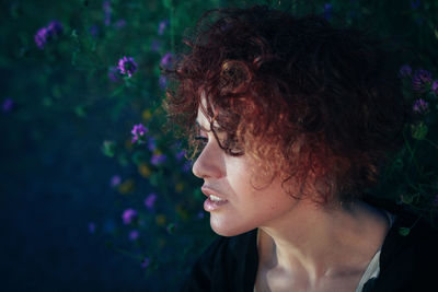 Woman looking away against purple flowers