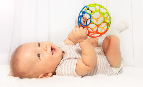 High angle view of cute baby boy lying on bed at home