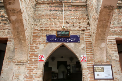 Low angle view of information sign on wall of building