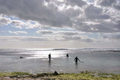 People on beach against sky