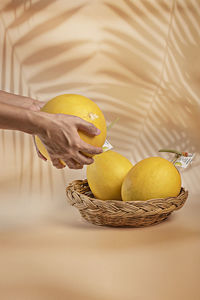 Close-up of hand holding fruit in basket