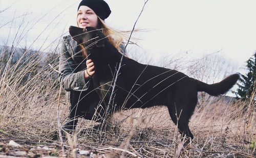 Young woman standing on field against sky during winter