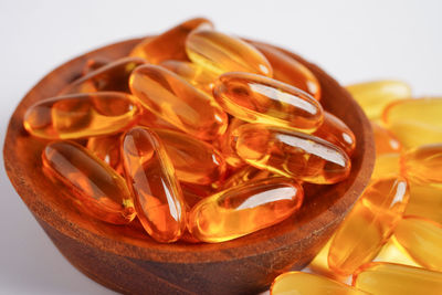 Close-up of pills in bowl against white background