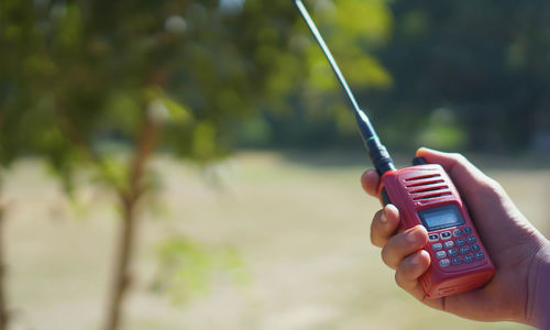 Close-up of hand holding mobile phone outdoors